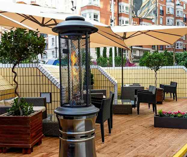 Terrass med möbler och värmare på ett trädäck. (AI-genererad text)