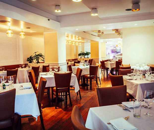 En elegant restaurang med dukade bord och bruna stolar. (AI-genererad text)