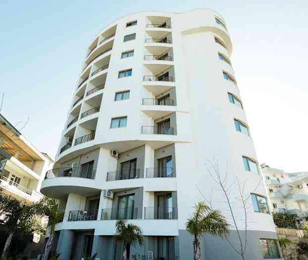 Höghus med vit fasad och balkonger. (AI-genererad text)