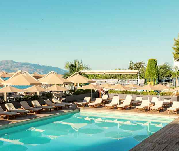 En utomhuspool omgiven av solstolar och parasoller. (AI-genererad text)