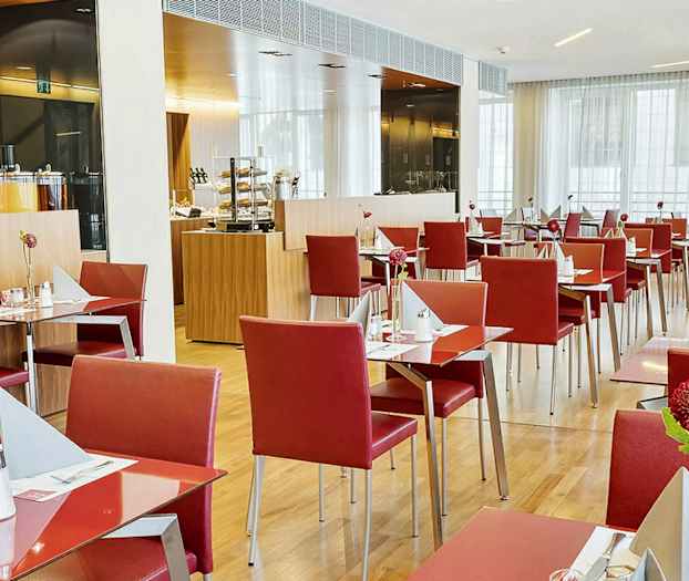 En restaurang med röda stolar och dukade bord. (AI-genererad text)