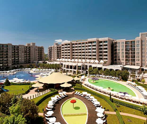 Hotellområde med stora byggnader, pooler och gröna ytor. (AI-genererad text)