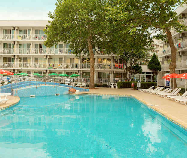 En utomhuspool med solstolar och parasoller framför en byggnad med balkonger. (AI-genererad text)