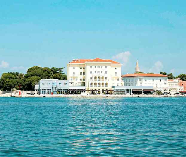 Bild av en byggnad vid en kust med blått hav och klar himmel. (AI-genererad text)