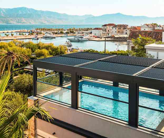 Takterrasspool med utsikt över hamn och berg. (AI-genererad text)