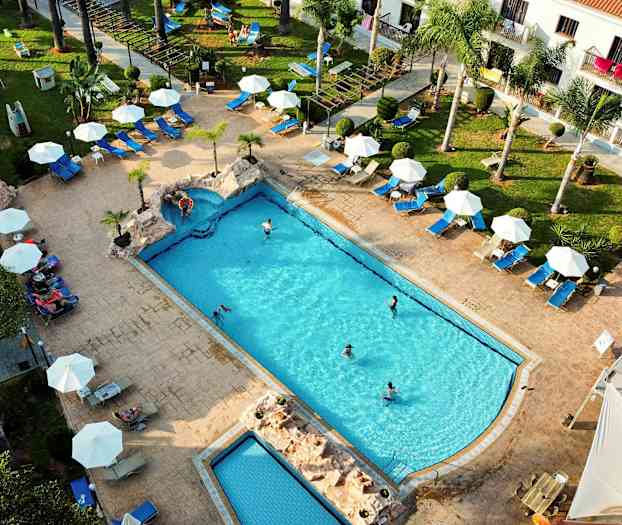 Flygfoto av en pool med omgivande solstolar och parasoller. (AI-genererad text)