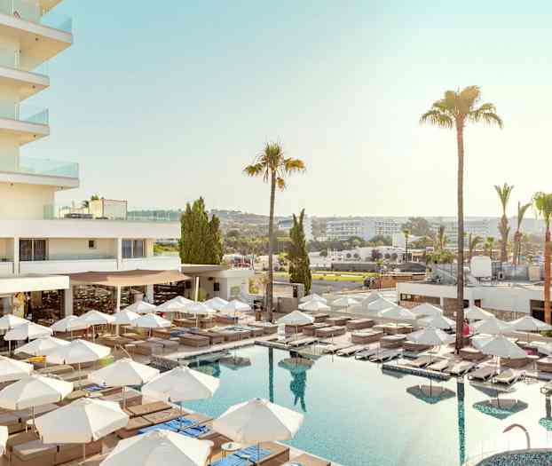 Hotellutsikt med pool, solstolar och parasoll. (AI-genererad text)