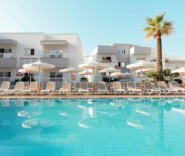 Bild av en pool med solstolar och parasoller framför ett hotell. (AI-genererad text)