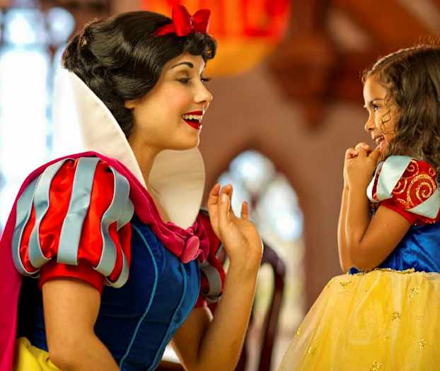 Två personer är klädda som Snövit och en prinsessa i en färgstark miljö. (AI-genererad text)