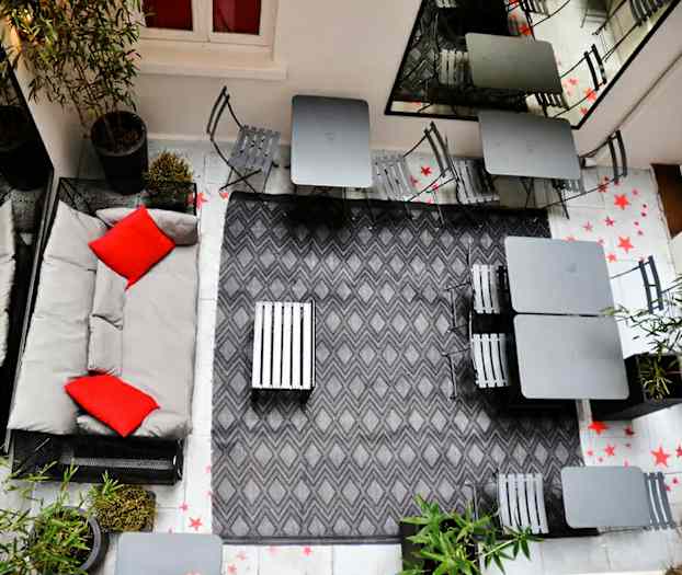 Innergårdsmiljö med sittplatser och grå inredning. (AI-genererad text)