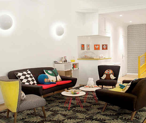 Ett vardagsrum med soffor och fåtöljer, dekorerat med färgglada kuddar och ett blommigt golv. (AI-genererad text)