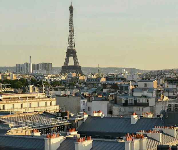 Eiffeltornet i Paris med omgivande byggnader i förgrunden. (AI-genererad text)