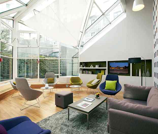 Modernt möblerat loungrum med stora fönster och bekväma sittplatser. (AI-genererad text)