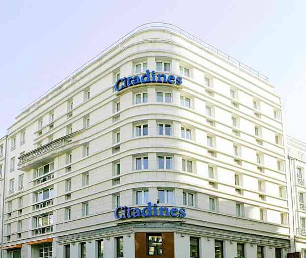 En byggnad med texten 'Citadines' på fasaden. (AI-genererad text)