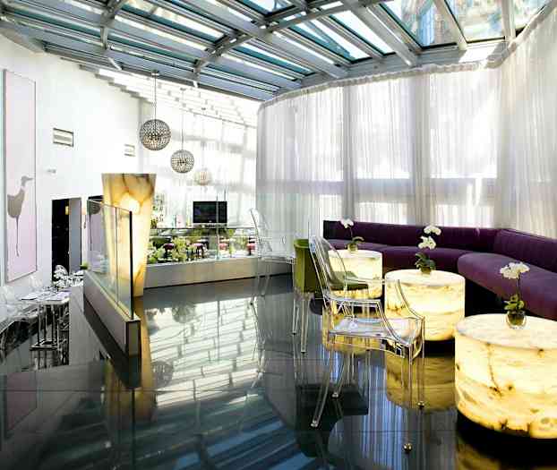 Modern lounge med glastak och ljusa sittmöbler. (AI-genererad text)