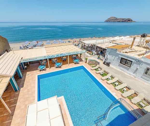 Bild av en utomhuspool med solstolar, restaurangområde och havsutsikt i bakgrunden. (AI-genererad text)