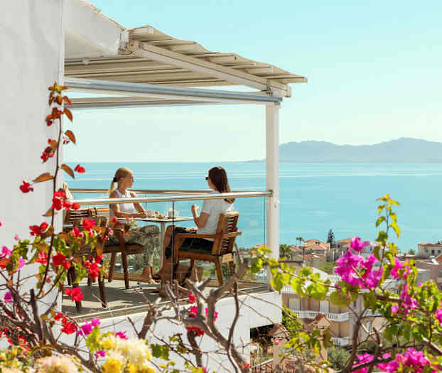 Två personer sitter på en terrass med utsikt över havet. (AI-genererad text)