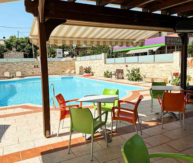 Utomhusbord med färgglada stolar vid en swimmingpool. (AI-genererad text)