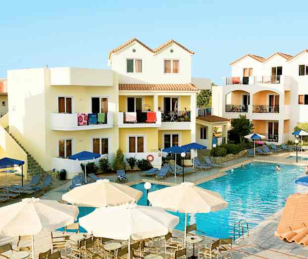 Ett hotellområde med en pool och omgivande byggnader med balkonger. (AI-genererad text)