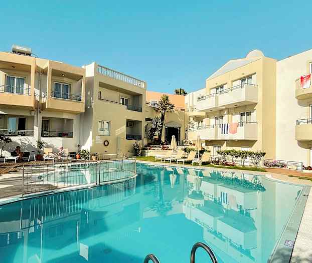 Exteriör av en byggnad med balkonger och en pool i förgrunden. (AI-genererad text)