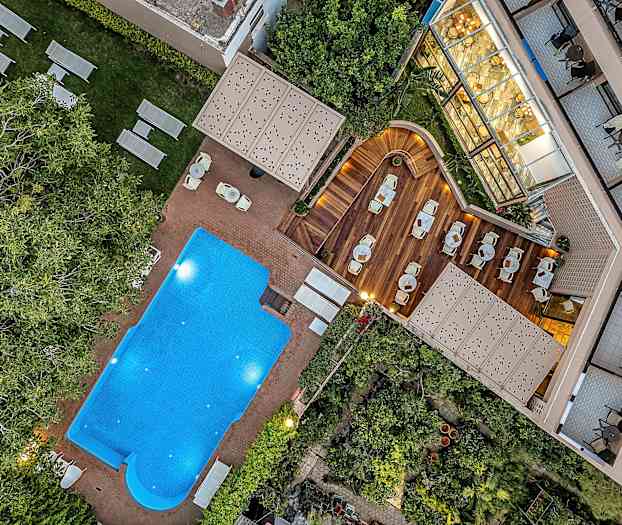 Bild av en utomhuspool, solstolar och en trädeck med sittplatser. (AI-genererad text)