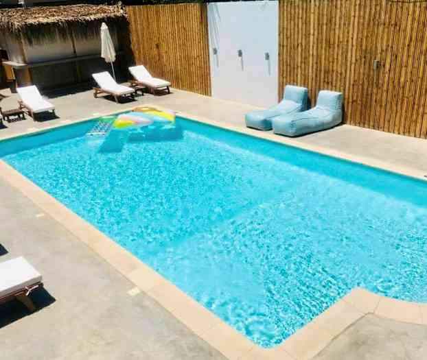 Utomhuspool med solstolar och badleksak. (AI-genererad text)