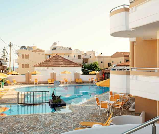 En pool med solstolar och parasoller vid ett hotell. (AI-genererad text)