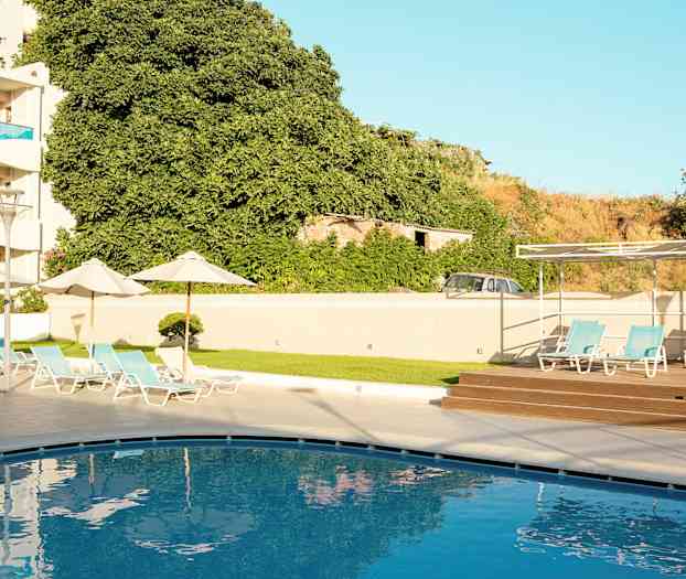 En swimmingpool med solstolar i en hotellmiljö. (AI-genererad text)