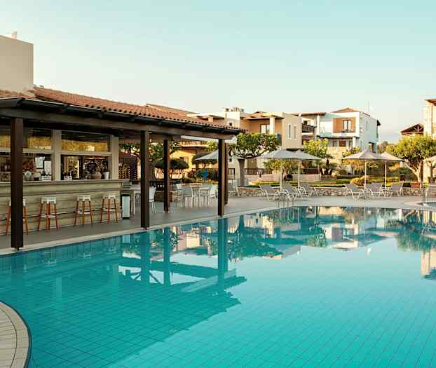 En utomhuspool med solstolar och parasoller, samt en bar med höga stolar intill. (AI-genererad text)