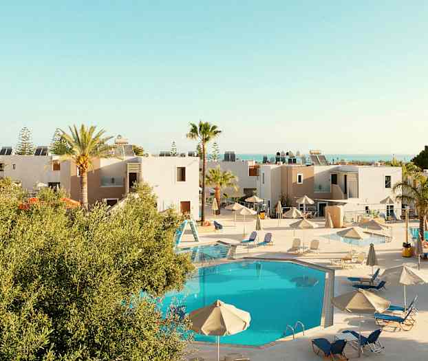 Utsikt över en semesteranläggning med pool och solstolar. (AI-genererad text)