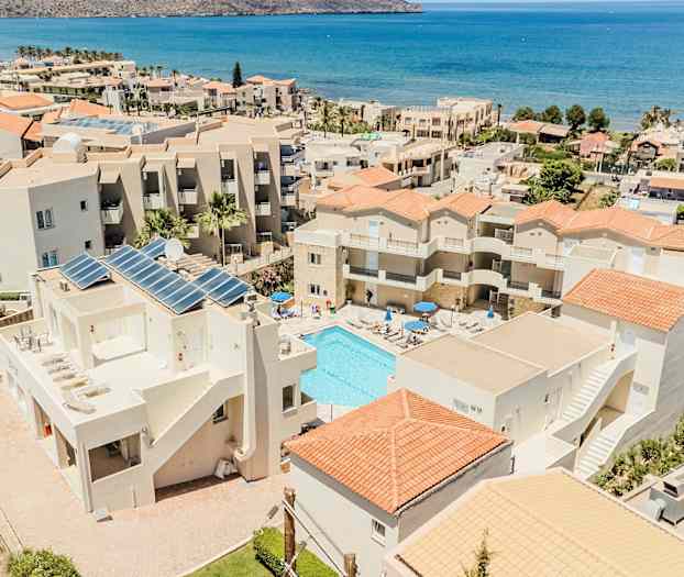 Hotellbyggnader med pool och hav i bakgrunden. (AI-genererad text)