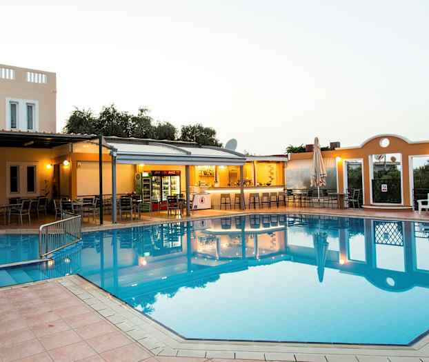 En utomhuspool vid ett hotell med intilliggande bar och sittgrupper. (AI-genererad text)