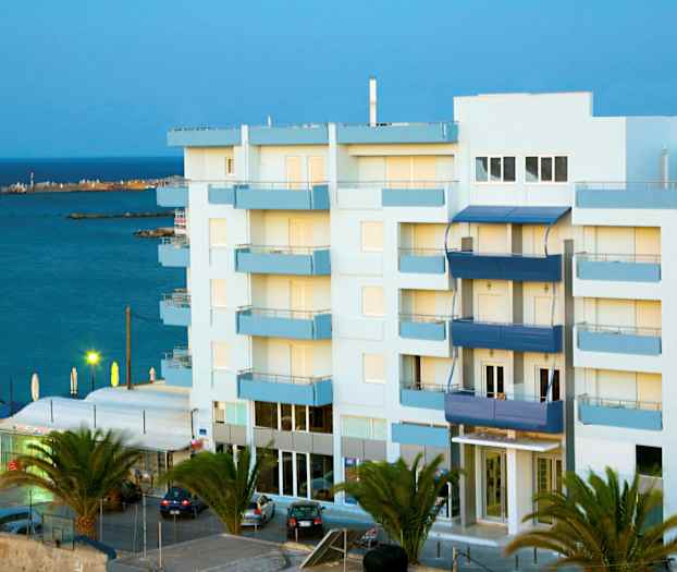 Flerfamiljshus nära havet, omgivna av palmer. (AI-genererad text)