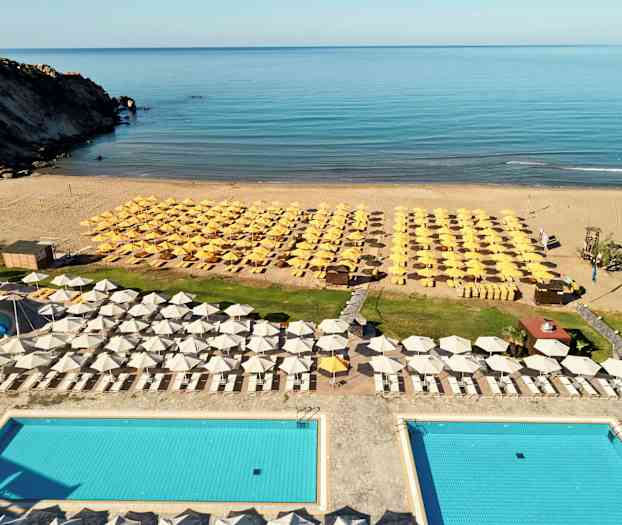 Utsikt över en poolområde med solstolar och parasoller vid stranden. (AI-genererad text)