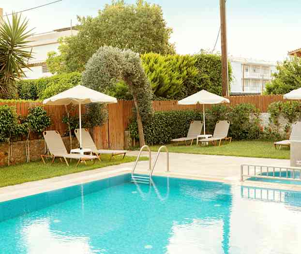 Utomhuspool med solstolar och parasoller samt grönskande omgivning. (AI-genererad text)