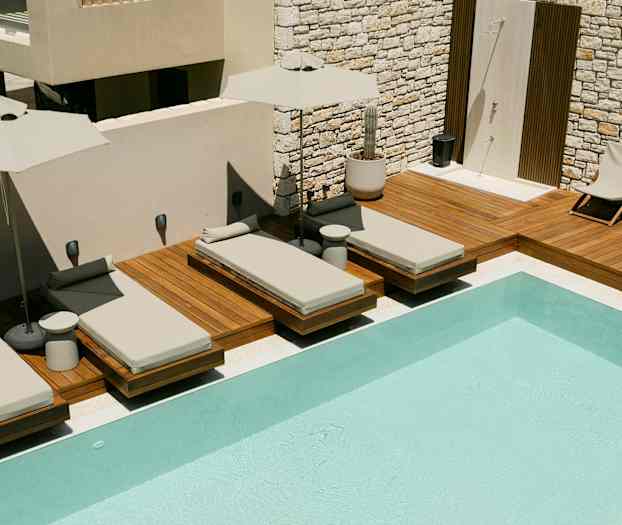 Solstolar vid en swimmingpool på en träaltan. (AI-genererad text)