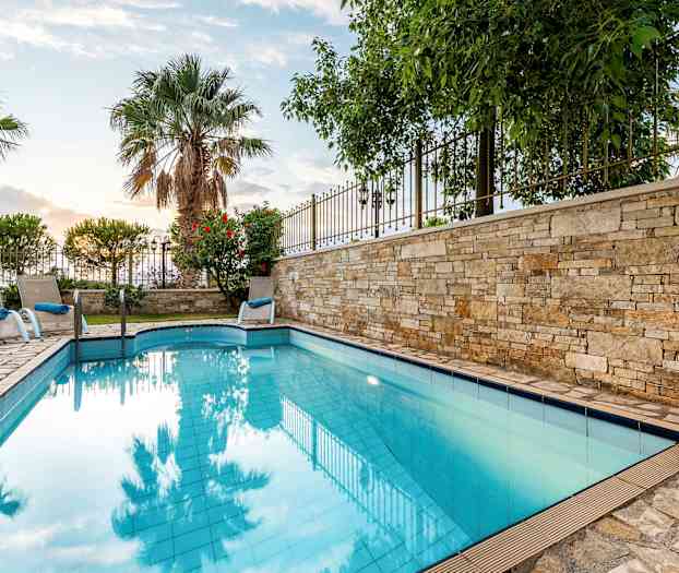 Utomhuspool med solstolar och palmer i bakgrunden. (AI-genererad text)