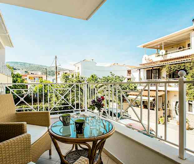 Balkong med utsikt över bostadshus, träd, och berg. (AI-genererad text)