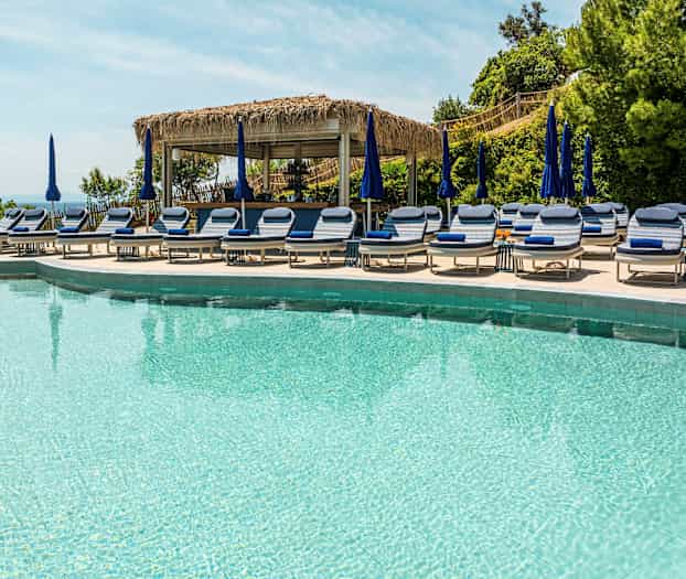 Pool med solstolar och parasoller. (AI-genererad text)