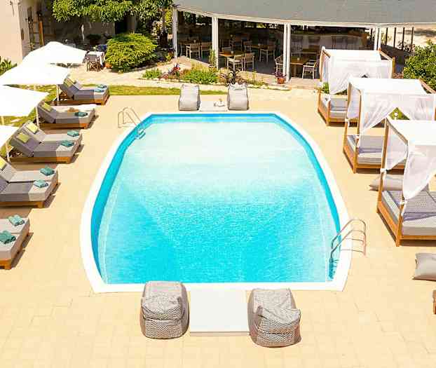 Utomhuspool omgiven av solstolar och baldakiner. (AI-genererad text)