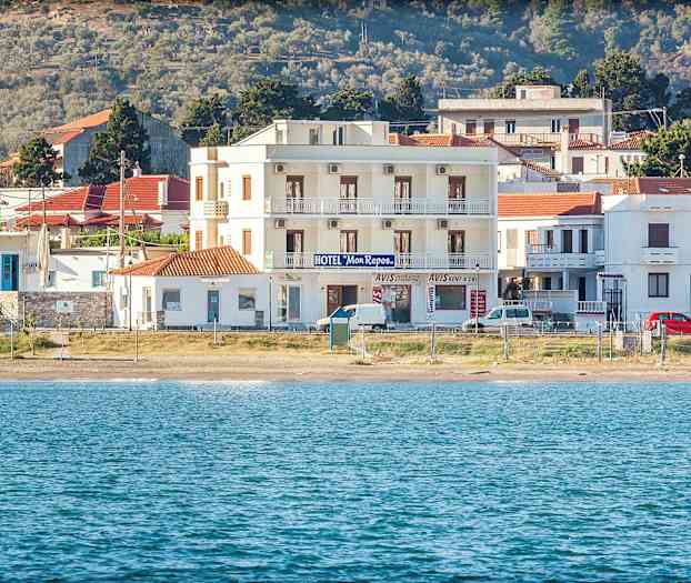 Hotellbyggnad vid strand med hav i förgrunden. (AI-genererad text)