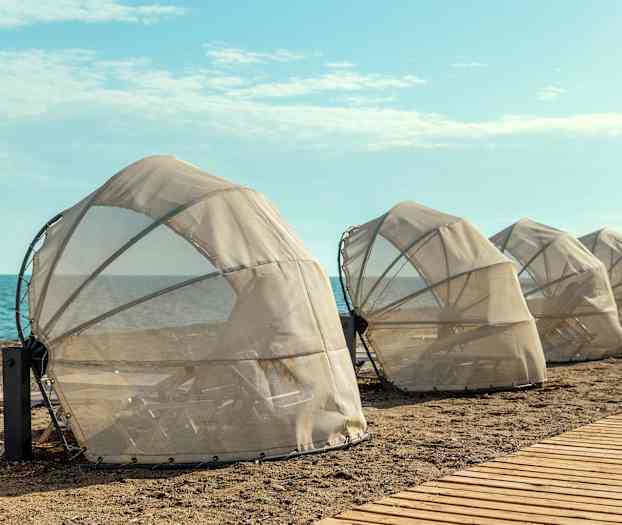 Skyddade solstolar på stranden nära havet. (AI-genererad text)