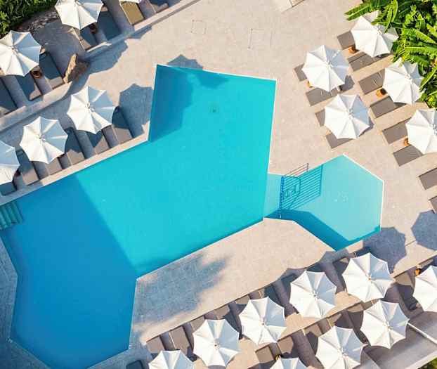 En pool med solstolar och parasoller runtom. (AI-genererad text)