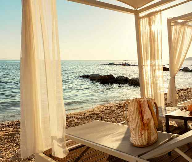 Solstolar och bord under ett gazebo vid havet. (AI-genererad text)