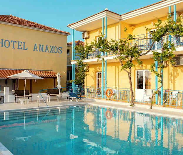 Hotell Anaxos med en utomhuspool framför byggnaden. (AI-genererad text)