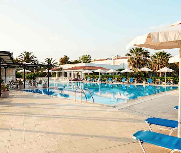 Bild av en pool med solstolar och parasoller omkring. (AI-genererad text)