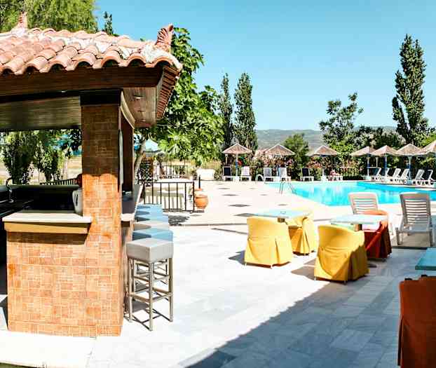 Bild av utomhusområde med en bar och sittplatser, solstolar och en pool. (AI-genererad text)