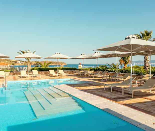 Poolområde med solstolar och parasoller, havsutsikt i bakgrunden. (AI-genererad text)