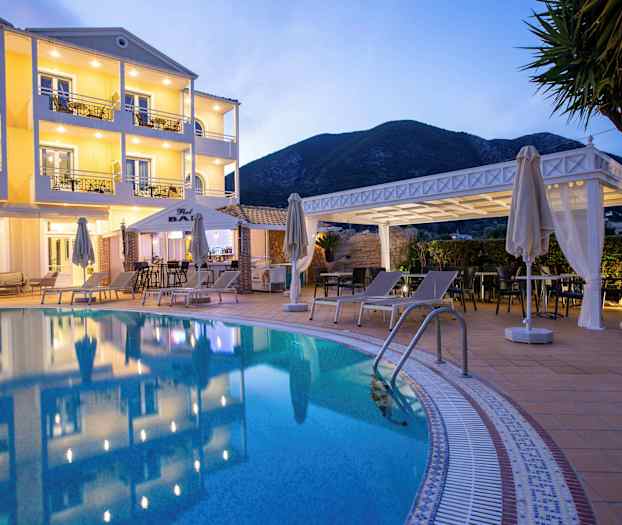 Hotellfasad med pool och solstolar i förgrunden. (AI-genererad text)