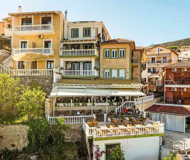 Flera byggnader med färgglada fasader och terrasser syns, belägna på en sluttning. (AI-genererad text)